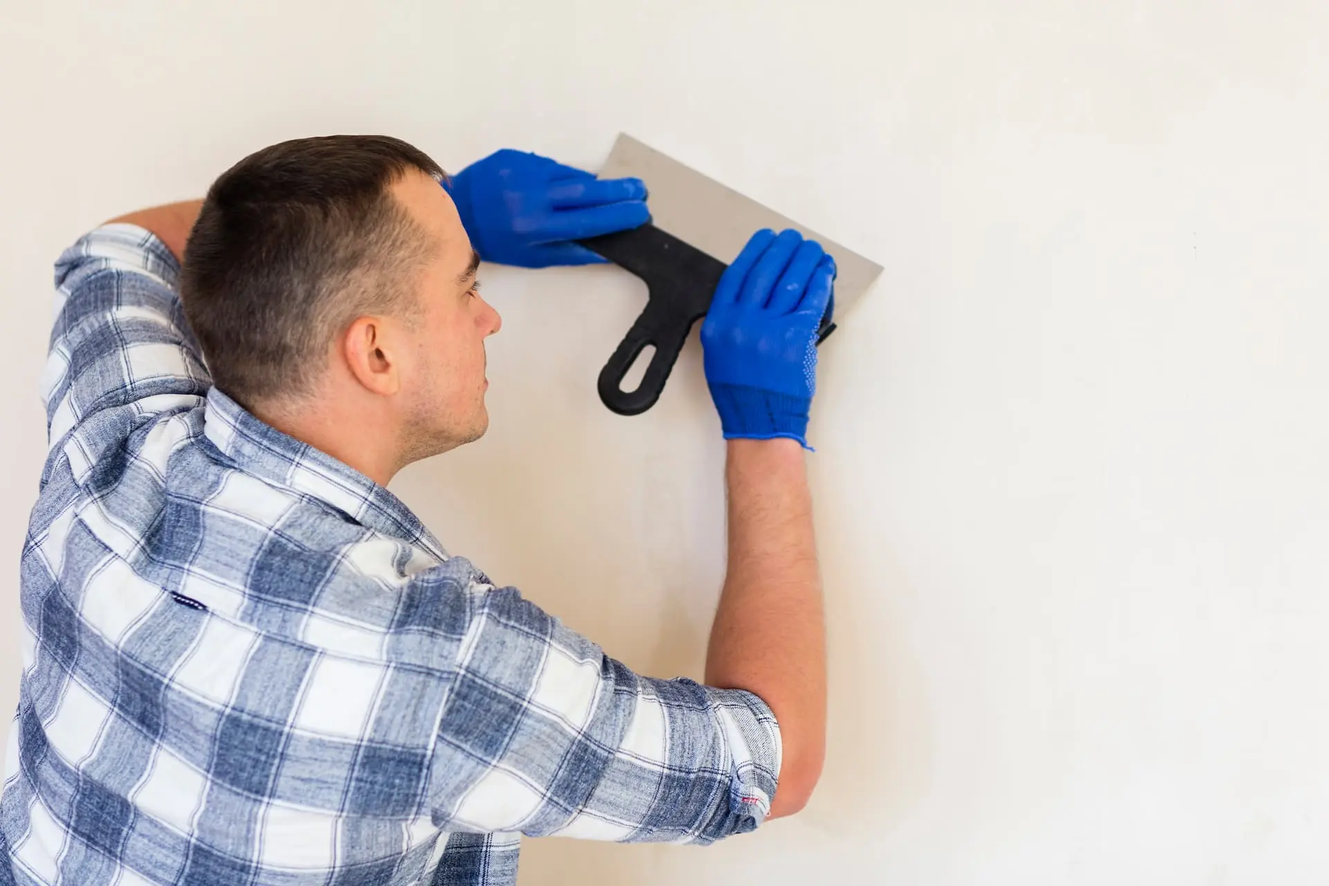 Profesional alisando una pared después de quitar gotelé